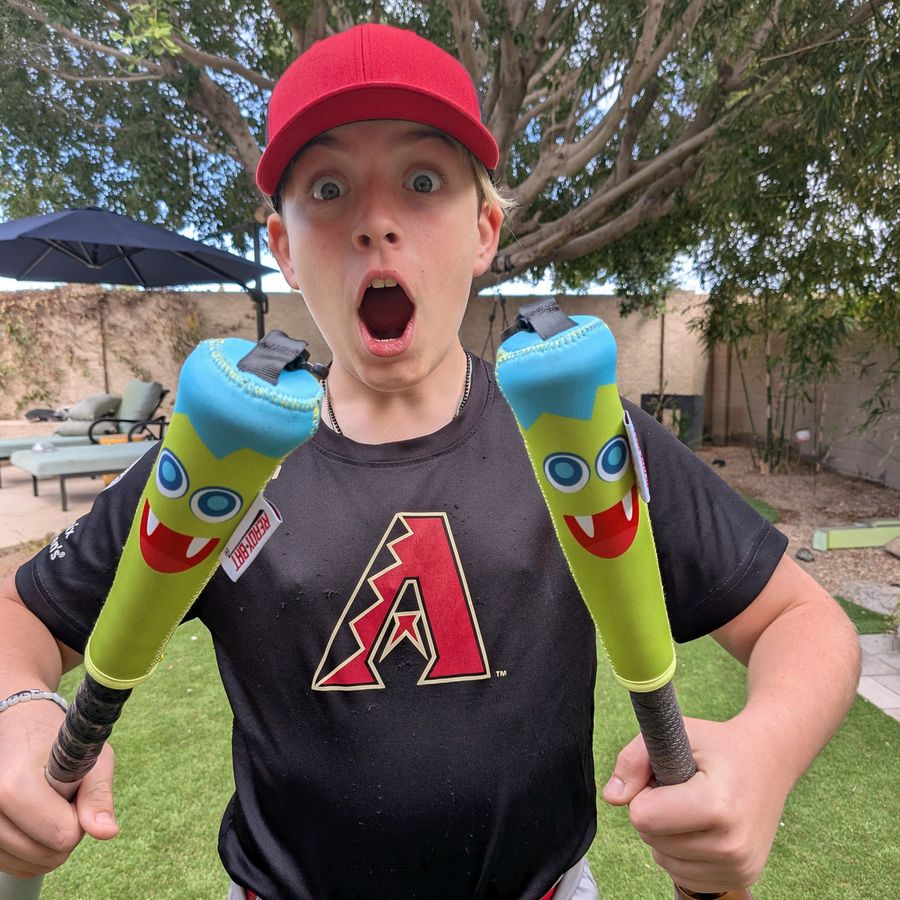 Kid holding two Lil Monster covered bats