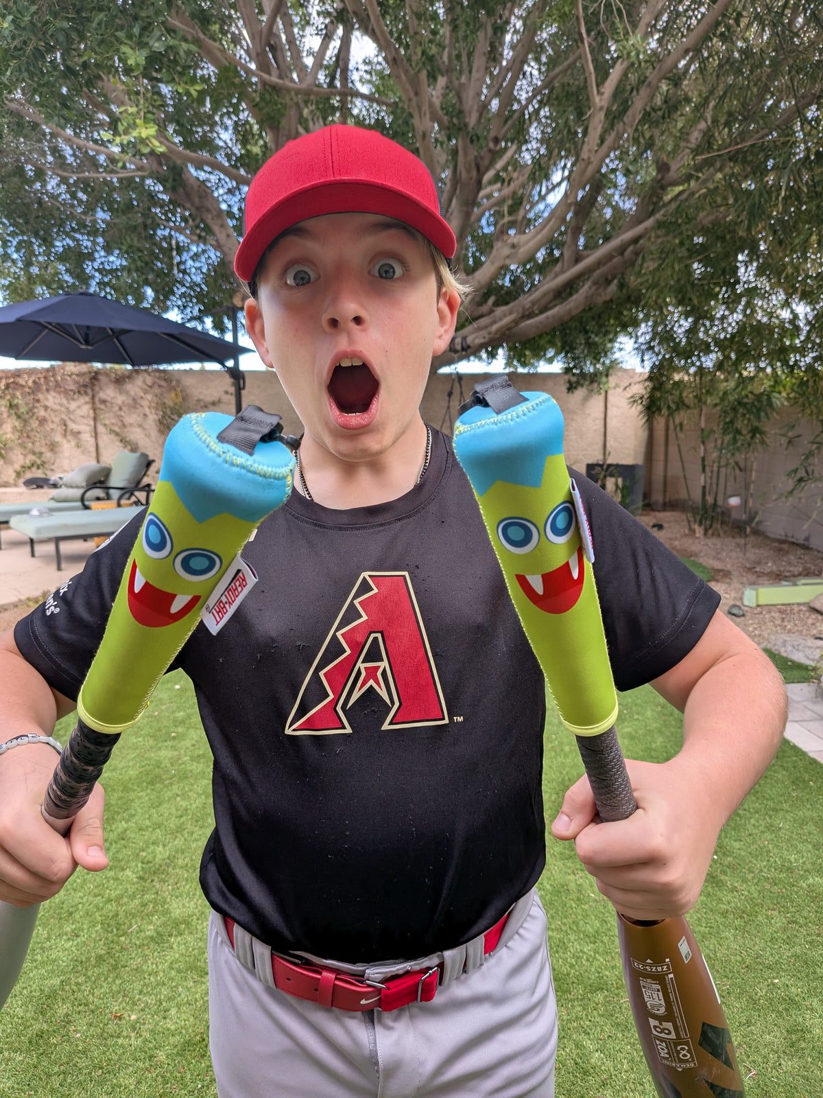 Kid holding two bats with Lil Monster Ready Bat covers