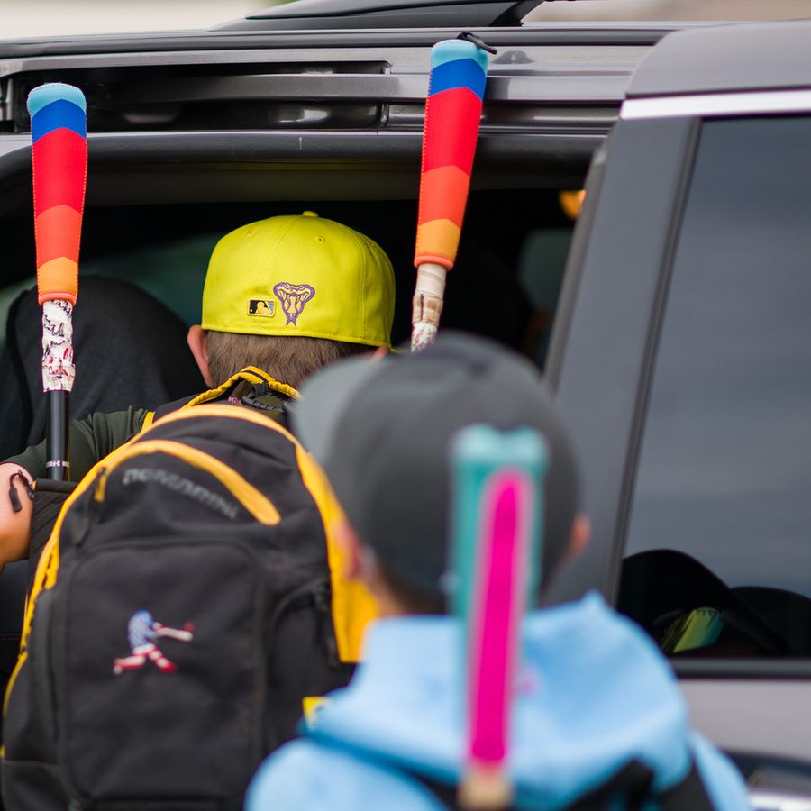 Kids loading bats with Ready Bat covers into a car